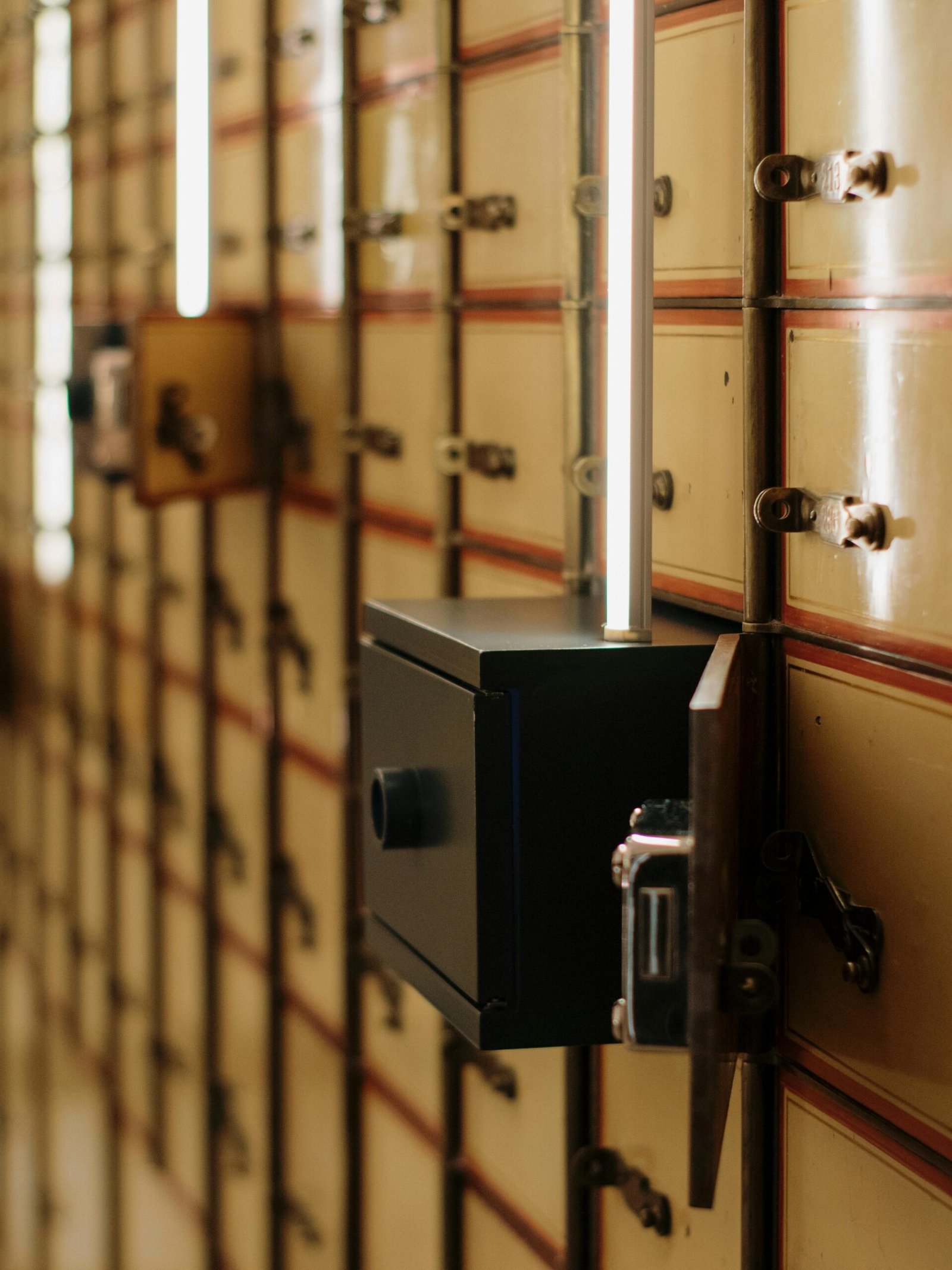 Close-up of vintage safety deposit boxes with one open, revealing secure interiors.